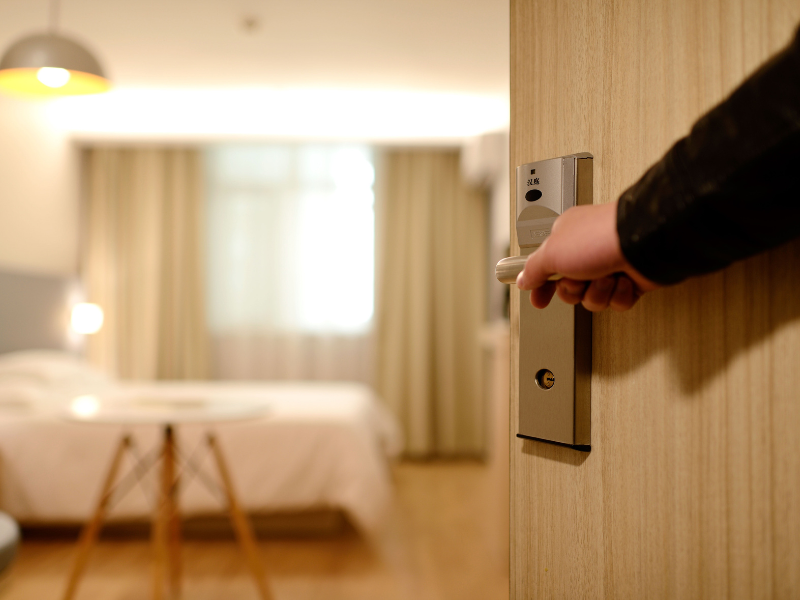 hospede abrindo a porta do quarto de hotel